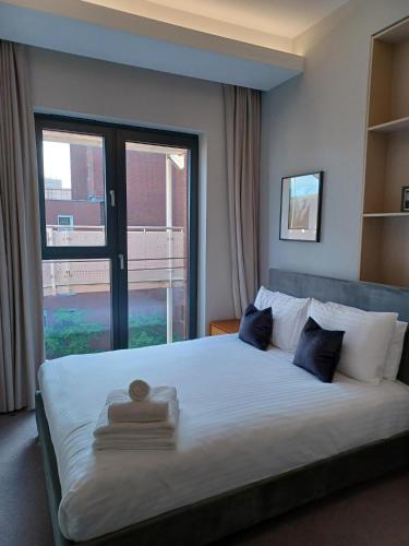 a bedroom with a large bed with a large window at Grays Inn by Aeria Apartments in London