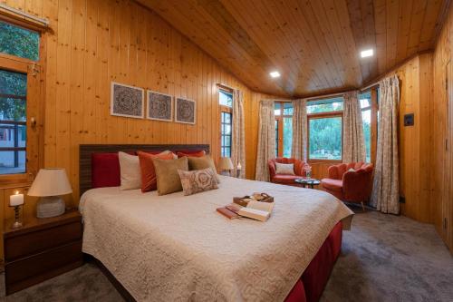 ein Schlafzimmer mit einem großen Bett in einem Zimmer mit Holzwänden in der Unterkunft LohonoStays Red Cottage at Zaznar in Srinagar