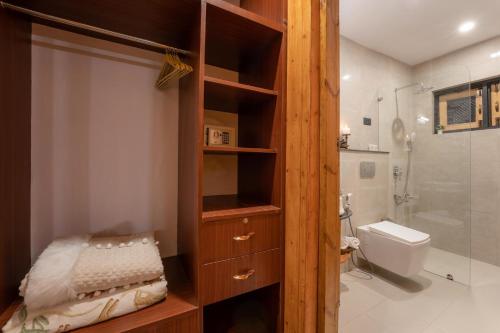 ein Badezimmer mit einem Holzschrank und einem WC in der Unterkunft LohonoStays Red Cottage at Zaznar in Srinagar