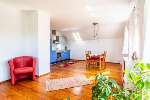 a living room with a red chair and a table at Elstar in Stockach