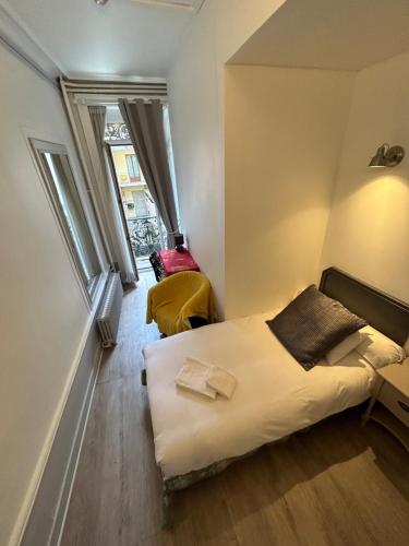 a small room with a bed and two windows at Le Carré d'Aix in Aix-les-Bains