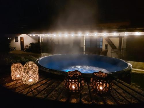 a hot tub on a grill at night with lights at Apartamenti Dundaga XXL in Dundaga