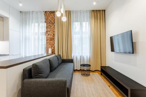a living room with a couch and a flat screen tv at Two Bedroom Very Berry Apartment in Poznań with Desk by Noclegi Renters in Poznań