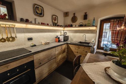 a kitchen with wooden cabinets and a sink and a table at La Casa del cuore in Fenis