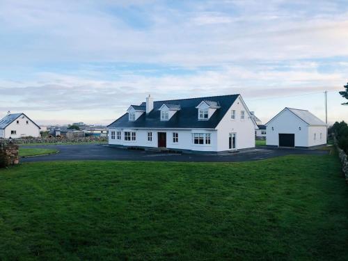 ein großes weißes Haus mit schwarzem Dach in der Unterkunft Connemara. 3 Bedroom, 8 bed, Holiday home in Galway