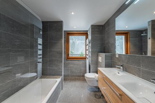 une salle de bain avec une baignoire, des toilettes et un lavabo dans l'établissement Les Flambeaux - Apt A13 - BO Immobilier - Châtel Multipass Été 2025 en option au tarif de 3euros par jour et par personne, à Châtel