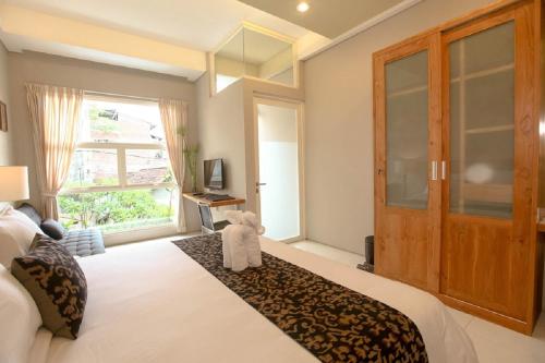 a bedroom with a bed with a teddy bear sitting on it at Bali True Living in Denpasar