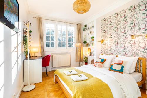 a bedroom with a bed with a yellow blanket at Double Appartements 210 sqm up to 18 guests, Villa des Ammonites 2&3 in Meudon