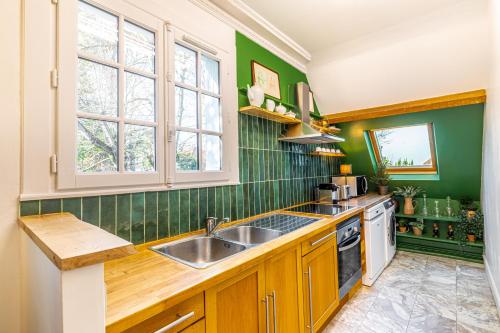a kitchen with green walls and a sink at Double Appartements 210 sqm up to 18 guests, Villa des Ammonites 2&3 in Meudon