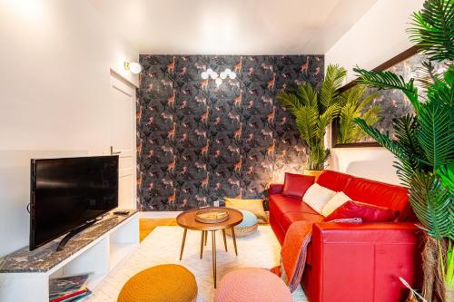 a living room with a red couch and a tv at Double Appartements 210 sqm up to 18 guests, Villa des Ammonites 2&3 in Meudon