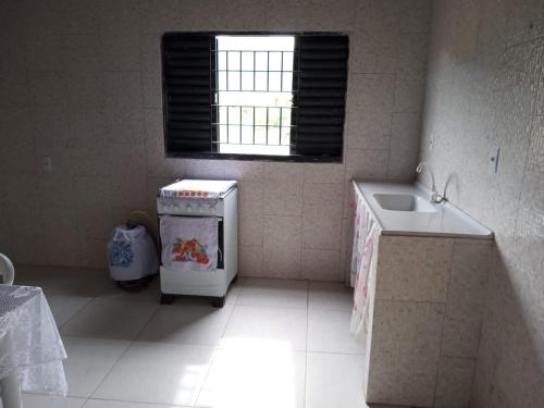 una pequeña cocina con fregadero y ventana en CASA TEMPORADA DONA CECÍLIA, en Cavalcante