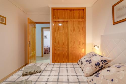 una camera da letto con un letto e una porta di legno di Bungalow 145 a Santa Pola