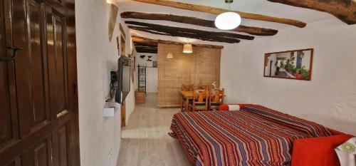 ein Schlafzimmer mit einem Bett und einem Tisch in einem Zimmer in der Unterkunft Casa Rural Vata 1 y 2 Pampaneira Alpujarra in Pampaneira