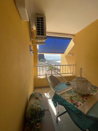 einen Balkon mit einem Tisch, einem Stuhl und einem Fenster in der Unterkunft Dulzura con vistas al mar in Puerto