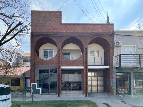 a red brick building with two large arched windows at Departamentos Plaza Santo Tomé, Santa Fe in Santo Tomé