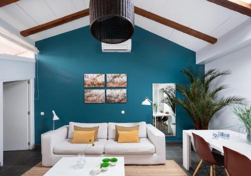 un soggiorno con divano bianco e parete blu di Carretas Attics Apartments a Madrid