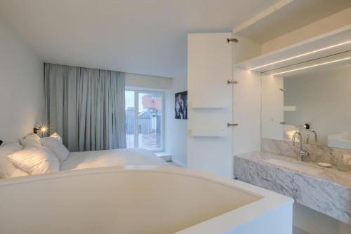 een witte slaapkamer met een bed en een wastafel bij Unique Appartment view MAS! in Antwerpen