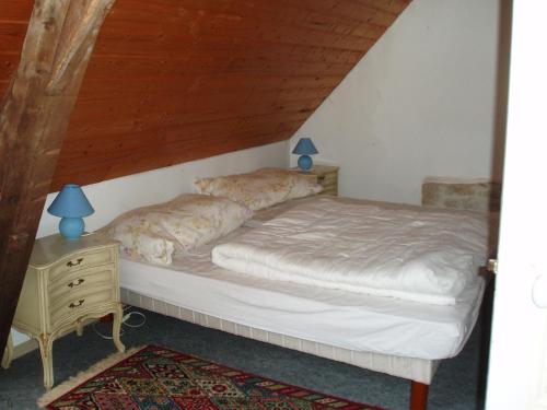Bett in einem Zimmer mit Holzdecke in der Unterkunft Les Poteries in Fresville