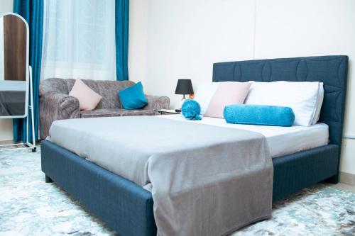 a bedroom with a large bed and a couch at Semo's apartment in Bamburi