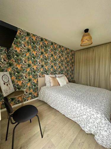 a bedroom with a bed and a floral wall at L'envolée - 15' de Paris & 10' du Stade de France in Saint-Denis