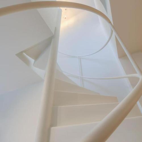 a white spiral staircase with a light on it at ANCHOR LODGE ANTWERP Unique Appartment view MAS! in Antwerp