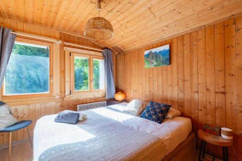 1 dormitorio con 1 cama en una habitación de madera en Quiet and Authentic Mountain Chalet, en Saint Pierre en Faucigny