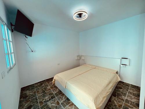 een kleine slaapkamer met een bed en een televisie bij Casa Turquesa en Tazacorte in Tazacorte