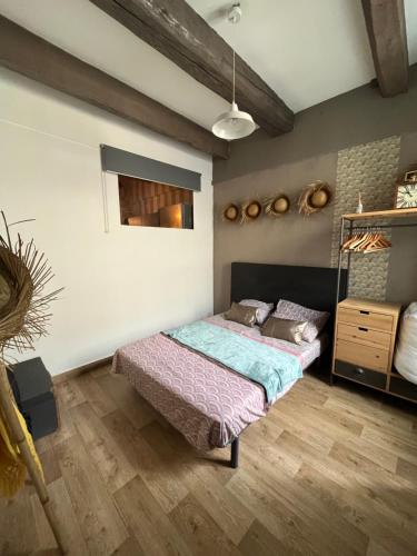 1 dormitorio con 1 cama y suelo de madera en L’authentique, en Nimes
