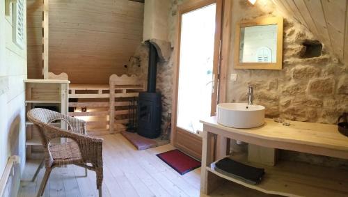 a bathroom with a sink and a wood stove at Chambres d`hôtes Le Plessis in Broye