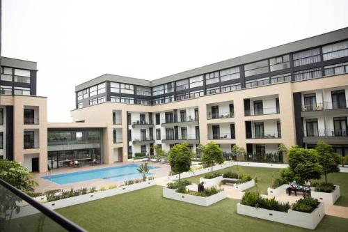 an apartment building with a courtyard and a swimming pool at Plush Studio @Embassy Gardens in Cantonments