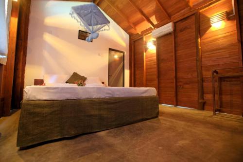 a bedroom with a bed with a light above it at The Mastodon Valley Safari Resort in Udawalawe