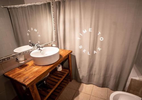 a bathroom with a sink and a shower curtain at Ruma Andina by DOT Cabana in Villa La Angostura