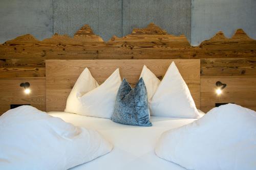 a large bed with white pillows on it at Gästehaus Brantlhof Zimmer und Ferienwohnungen in Going am Wilden Kaiser in Going