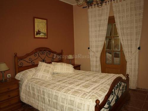 a bedroom with a bed with a white comforter and a window at Complejo en el medio del campo! 