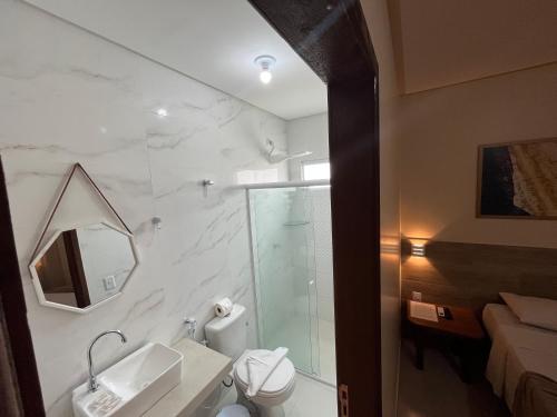 a bathroom with a shower and a toilet and a sink at Pousada Donna Maraka in Porto De Galinhas