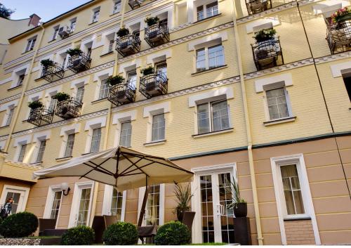 um edifício amarelo com um guarda-chuva em frente em Vozdvyzhensky Boutique Hotel em Kiev