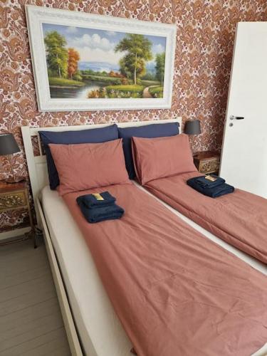 a bedroom with two beds and a painting on the wall at River Run Ranch - Telemark in Drangedal