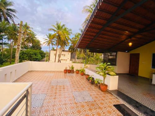 einen Balkon eines Hauses mit Palmen in der Unterkunft Pal's Cottage in Mysore