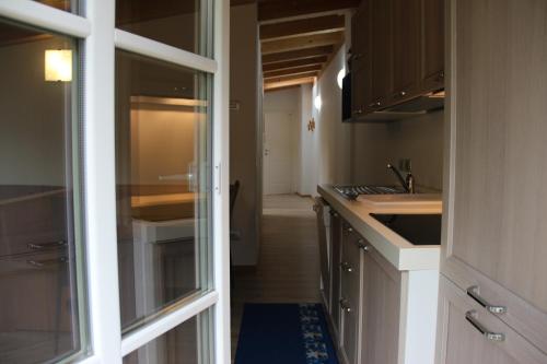 une cuisine avec une porte menant à un couloir dans l'établissement Claudia's Apartment Blu, à Alba di Canazei