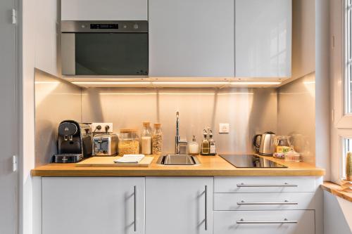 une cuisine avec un évier et un micro-ondes dans l'établissement La Souche, à Rouen