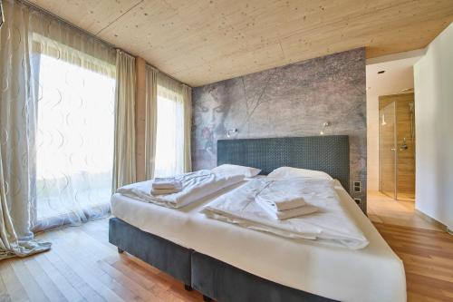 a large bed in a room with a large window at Holiday Penthouse Holleis in Maishofen