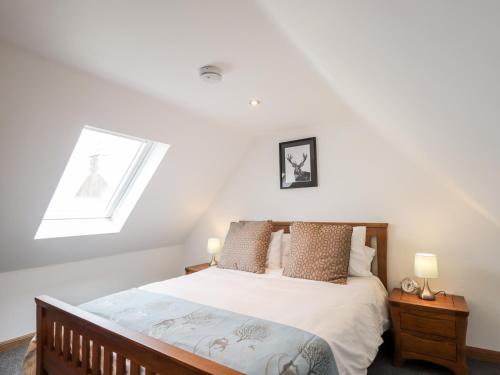 a bedroom with a bed and a skylight at Corner Cottage in Buckie