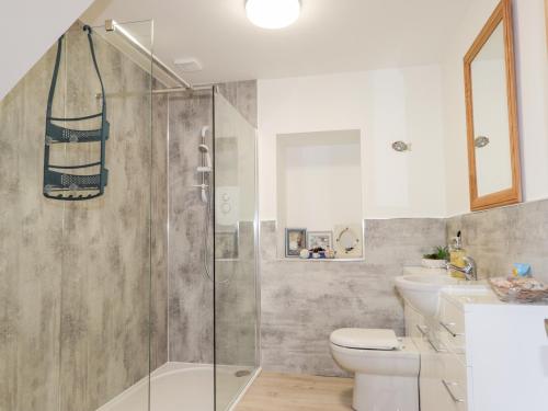 a bathroom with a shower and a toilet and a sink at Corner Cottage in Buckie