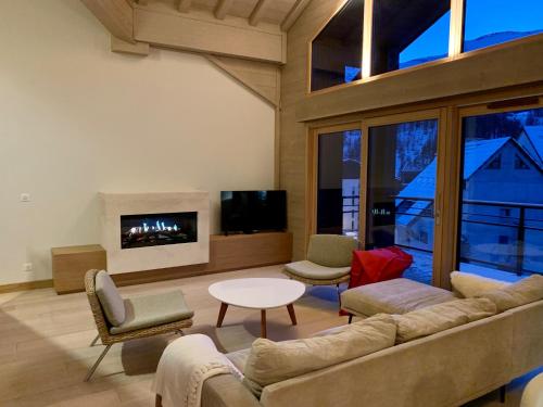 sala de estar con sofá y chimenea en Le chalet sous-toiture Nánshān : spacieux, lumineux et idéalement situé à Auron, en Auron