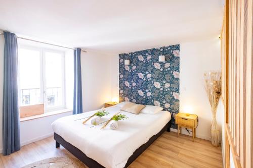 a bedroom with a large bed with a floral wall at Petit cocon au centre d'Annecy in Annecy
