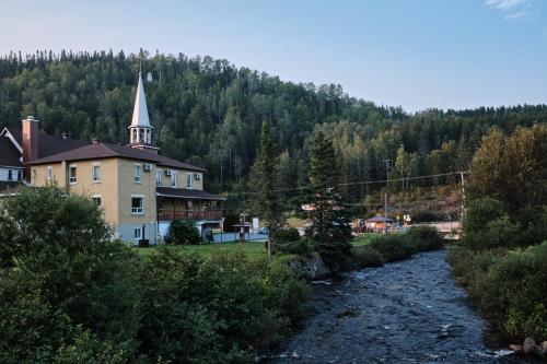 een kerk en een rivier voor een gebouw bij AUBERGE DU DIMANCHE - Riviere-Eternite, Pres du Fjord-du-Saguenay et de l'Anse-Saint-Jean in Riviere Eternite