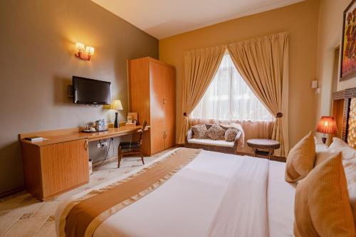 Habitación de hotel con cama grande y escritorio. en The Amariah Hotel & Apartments Mikocheni, en Dar es Salaam