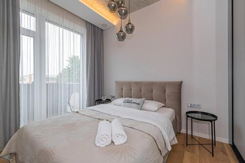 a bedroom with a large bed with two white towels on it at Comfortable 1 BD Old Town Apartment by Hostlovers in Kaunas