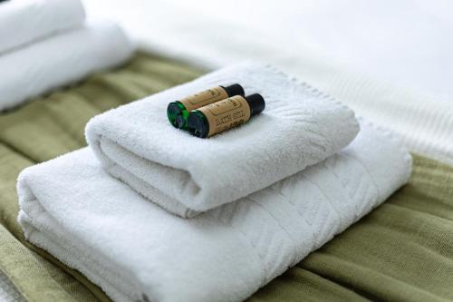 a bottle on a pile of towels on a bed at Lovely 1BR Flat, Prime Location Bloomsbury, Euston in London