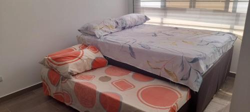 um quarto com uma cama de solteiro e uma janela em CONDOMINIO LA ISABELLA ANAPOIMA em Anapoima